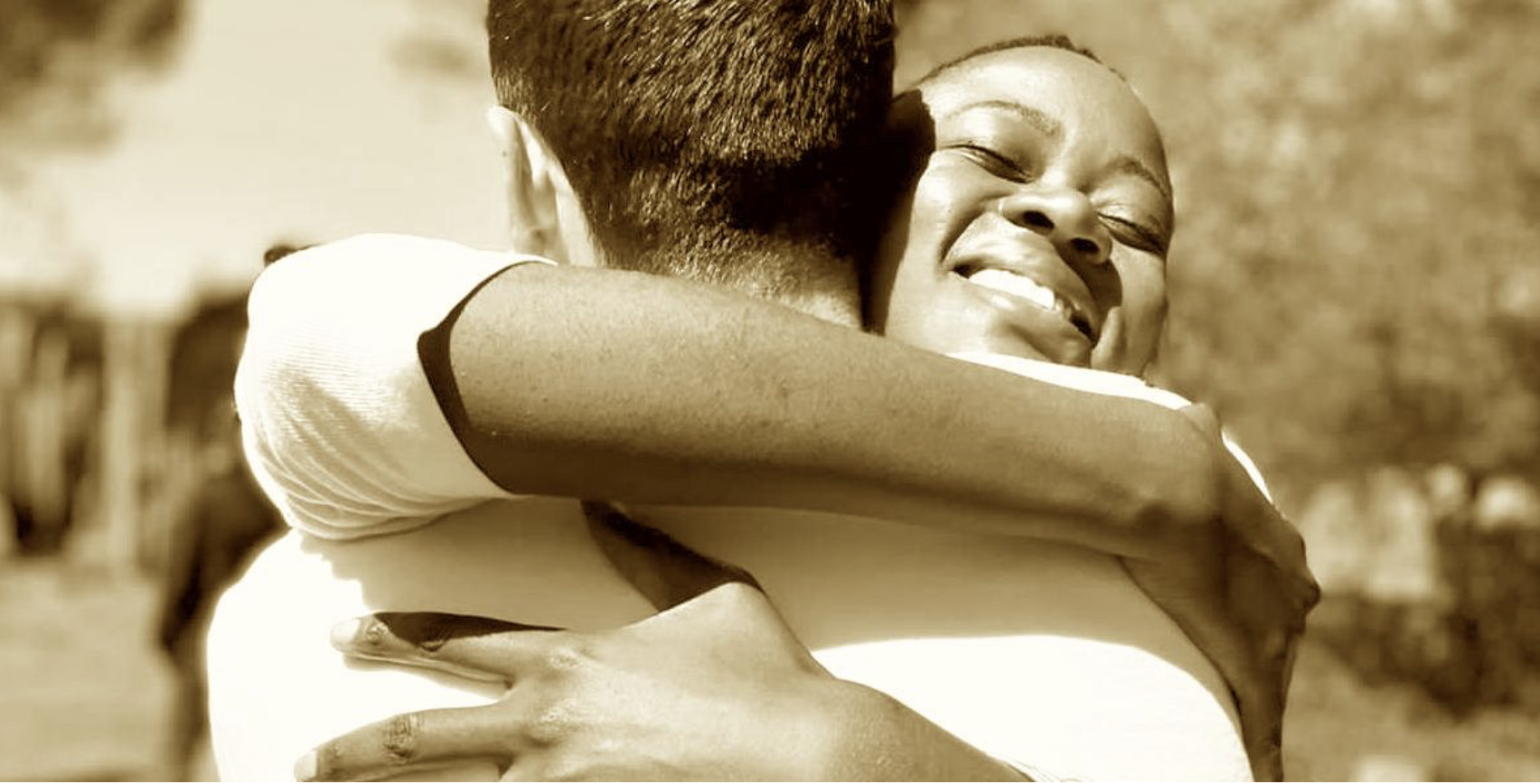Two people embracing warmly, sepia tone